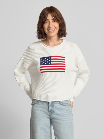 Vrouwenmodel draagt gebreide pullover met Amerikaanse vlag van GAP, puur katoen, regular fit, grof tricot, ronde hals, ruglengte maat S 47 cm, mouwlengte maat S 51 cm, vooraanzicht bovenlichaam