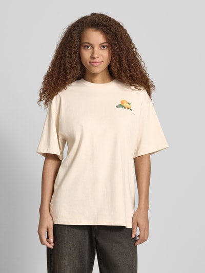 Frauenmodel trägt T-Shirt mit rückseitigem Motiv-Print von REVIEW aus Reine Baumwolle, Oversized, Rundhalsausschnitt, Vorderansicht, Nahaufnahme Oberkörper.