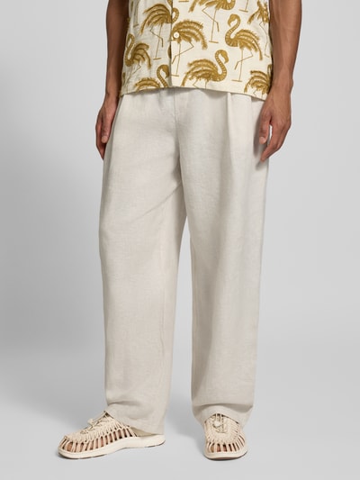 Männermodel trägt Relaxed Fit Leinenhose aus reinen Leinen von JAKE*S STUDIO MEN in Naturweiß, elastischer Bund, semitransparente Optik, Nahaufnahme Unterkörper.