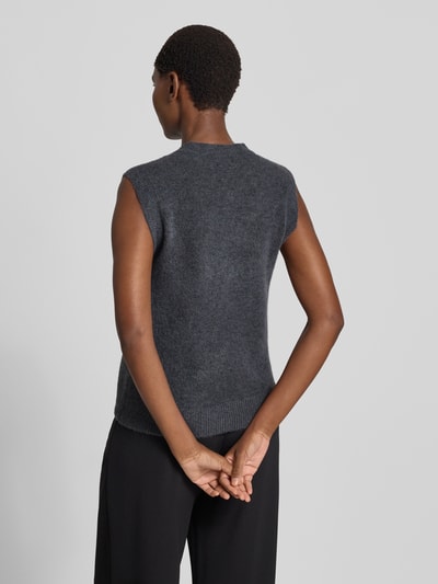 Frauenmodel trägt Strickweste mit Rundhalsausschnitt Modell 'Bondie Hope' von MSCH Copenhagen, klassische Knopfleiste, Strukturmix in Dunkelgrau, Damen Regular Fit, glatte und leicht flauschige Textur, Rückenansicht, Ganzkörperansicht Rückansicht, Rückenlänge bei Größe S/M: 58 cm, Mix mit Woll-Anteil.