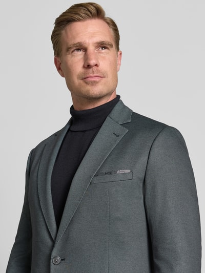 Männermodel trägt Regular Fit Sakko mit Viskose-Anteil Modell 'Data' von CINQUE in mittlerem Grau, Nahaufnahme Oberkörper. Elastischer Material-Mix, Reverskragen, Pattentaschen und 2-Knopfleiste sind sichtbar.