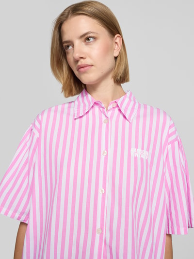 Frauenmodel trägt Cropped Bluse mit Label-Stitching Modell 'VEXTOWN' von American Vintage, rosa-weiß gestreift, Reine Baumwolle, Nahaufnahme Oberkörper.