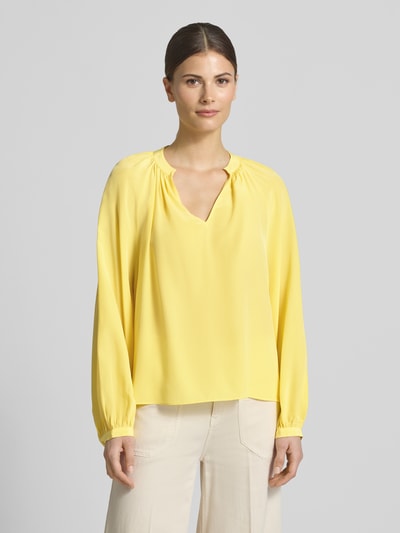 Kobiece model prezentuje Regular Fit Bluse mit V-Ausschnitt od HERZENS, kolor żółty, kołnierz z lamówką, długość tyłu 58 cm, długość rękawów 66 cm, krój regular fit, delikatny materiał, widok całego ciała z przodu.