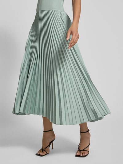 Vrouwenmodel draagt Regular Fit Businesskleid uit verschillende materialen model 'FADRIDI' van BOSS, effen kleuren, midilengte, ronde hals, plissérok van satijn, korte mouw, materiaalverwerking ribtricot, satijn en plissé, detailopname onderlichaam.