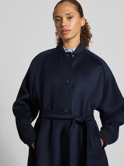 Frauenmodel trägt Regular Fit Steppmantel aus reiner Schurwolle Modell 'ABBONO' von Weekend Max Mara in Dunkelblau, Nahaufnahme Oberkörper.
