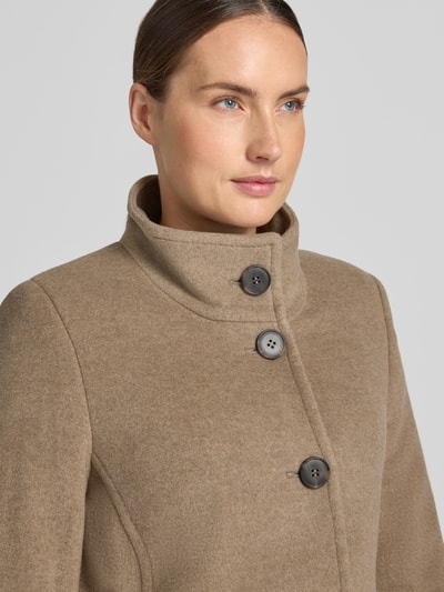 Frauenmodel trägt Jacke mit Stehkragen und Eingrifftaschen von FUCHS SCHMITT, Mieszanka materiałów z dodatkiem wełny, linia a, listwa guzikowa, wpuszczane kieszenie, długość tyłu w rozmiarze 36: 73 cm, szerokość ramion w rozmiarze 36: 37 cm, szerokość w rozmiarze 36: 48 cm, długość rękawów w rozmiarze 36: 64 cm, jasnobrązowy odcień, tekstura miękka, zbliżenie na górną część przodu