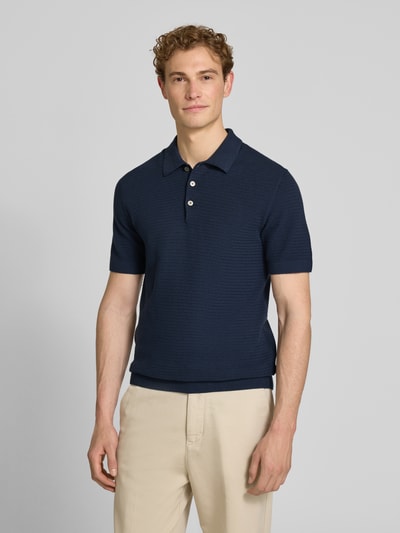 Männermodel trägt Regular Fit Poloshirt mit Strukturmuster Modell 'Riley' von Jack & Jones Premium in Dunkelblau, reine Baumwolle, Kurzarm, Ganzkörperansicht von vorne.