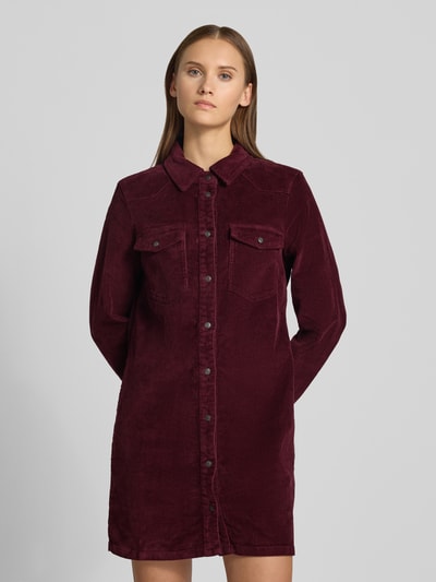 Frauenmodel trägt Hemdblusenkleid aus Cord mit Brusttaschen von NOISY MAY®, Dunkelrot, gerader Schnitt, Hemdblusenkragen, Minilänge, Ganzkörperansicht von vorne.
