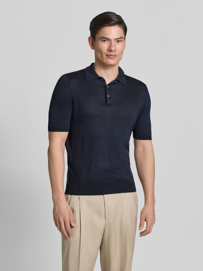 Männermodel trägt Slim Fit Poloshirt aus reiner Seide von GRAN SASSO in Dunkelblau, semitransparent, kurzärmelig, Ganzkörperansicht von vorne.