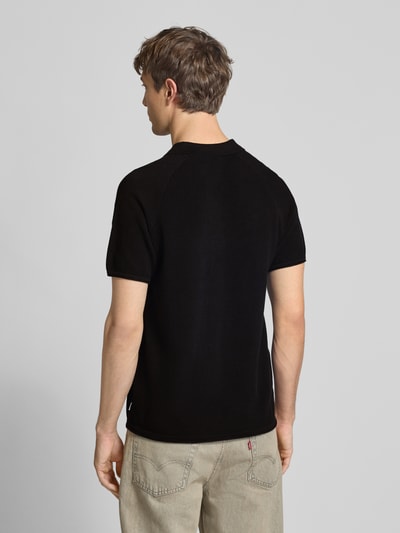 Männermodel trägt Regular Fit Poloshirt mit Strukturmuster Modell 'HILL' von Jack & Jones in Schwarz, Baumwolle, Ganzkörperansicht Rückansicht.