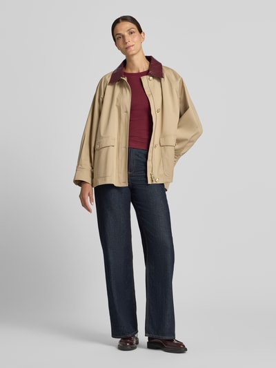 Frauenmodel trägt Slim Fit Langarmshirt aus Baumwoll-Mix Modell 'CHLOE' von VERO MODA in Dunkelrot, kombiniert zu Jeans, Ganzkörperansicht von vorne.