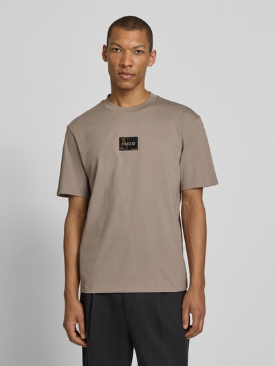 Männermodel trägt Regular Fit T-Shirt aus reiner Baumwolle Modell 'DUMEON' von HUGO, Optik: Unifarben, Label-Applikation, Rundhals, Kurzarm, Materialverarbeitung: Jersey, Ganzkörperansicht von vorne.