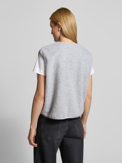 Frauenmodel trägt Weste mit Rundhalsausschnitt Modell 'HOKTOWN' von American Vintage, hellgrauer Teddyfellstoff, lockerer Schnitt, Ganzkörperansicht Rückansicht.