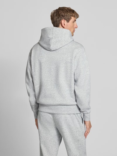 Männermodel trägt Hoodie mit Label-Stitching von Champion in Hellgrau, lockerer Schnitt, Rückansicht, Baumwoll-Mix, Ganzkörperansicht Rückansicht.