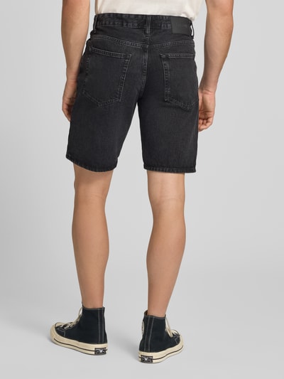 Männermodel trägt Straight Leg Jeansshorts aus reiner Baumwolle Modell 'EDGE' von Only & Sons in Denim-Optik, Label-Patch, 5-Pocket-Design, Ganzkörperansicht Rückansicht.