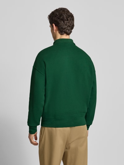 Männermodel trägt Regular Fit Sweatshirt aus Baumwoll-Mix von Polo Ralph Lauren in Dunkelgrün, gerippte Abschlüsse, unifarben, Ganzkörperansicht Rückansicht.