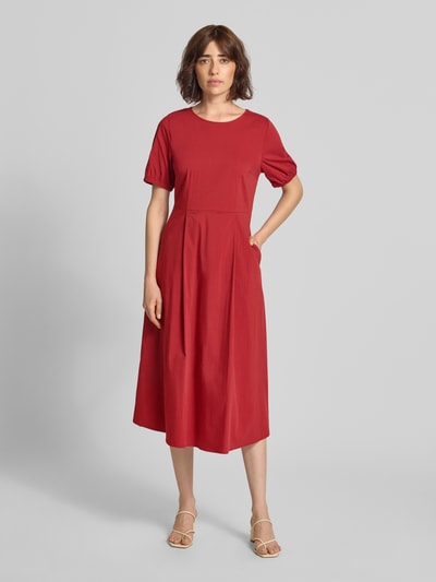Frauenmodel trägt Midikleid mit Rundhalsausschnitt von MORE & MORE in Rot, A-Linie, Baumwoll-Mix mit Stretch, Ganzkörperansicht von vorne.
