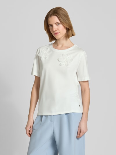 Frauenmodel trägt Regular Fit T-Shirt mit floralem Zierbesatz von monari aus Baumwoll-Modal-Mix, weiß, mit Rundhalsausschnitt, Rückenlänge bei Größe 36: 59 cm, Ganzkörperansicht von vorne.