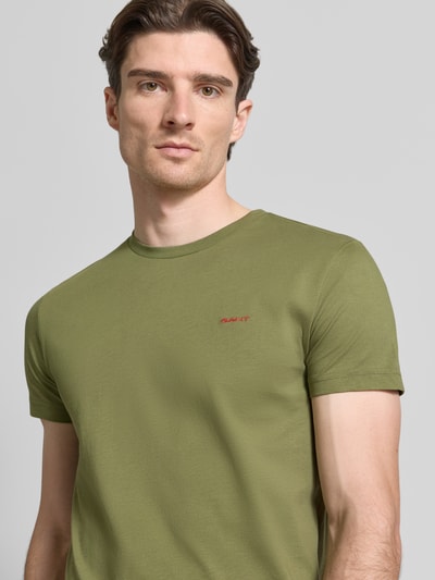 Männermodel trägt T-Shirt mit Label-Detail von Gant in Olive, reine Baumwolle, gerader Schnitt, Rundhalsausschnitt, Nahaufnahme Oberkörper