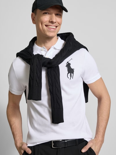 Männermodel trägt Shaped Fit Poloshirt aus reiner Baumwolle von Polo Ralph Lauren, Optik: Unifarben, Logo-Stitching, Polokragen, Struktur Piqué, Ganzkörperansicht von vorne.