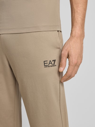 Męski model nosi Spodnie dresowe mit Logo i elastycznym pasem od Armani, mieszanka bawełny i elastanu, krój regular fit, logo, długość wewnętrzna nogawki 74 cm, zbliżenie na górną część nogawki.