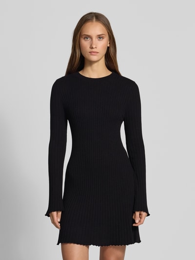 Frauenmodel trägt Eng anliegendes Freizeitkleid aus Viskose-Mix Modell 'MICHELLA' von ONLY, schwarze Farbe, gerippte Struktur, Ganzkörperansicht von vorne, Damen Strickkleid von ONLY.