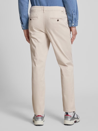 Männermodel trägt Straight Fit Chino mit Eingrifftaschen Modell 'Vance' von Jack & Jones, mieszanka bawełny, wpuszczane kieszenie, krój straight fit, kieszenie z tyłu, zapięcie na guzik i zamek błyskawiczny, szerokość w rozmiarze 32/32: 43 cm, długość wewnętrzna nogawki w rozmiarze 32/32: 67 cm, jasny beż, gładka faktura, całkowity widok z tyłu