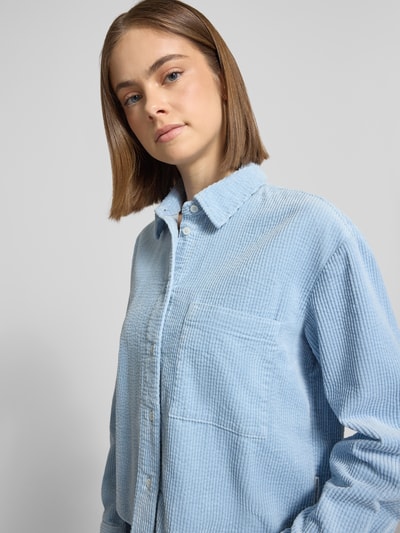 Vrouwenmodel draagt Relaxed Fit Hemdbluse aus reiner Baumwolle van Marc O'Polo Denim in effen kleuren corduroy, borstzak, lichte textuur, nahaufnahme bovenlichaam.