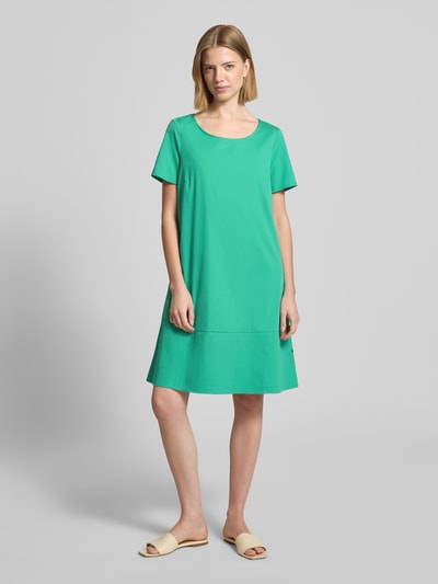 Frauenmodel trägt Minikleid mit rückseitigem Knopfverschluss von ROBE LÉGÈRE in Grün, A-Linie, Baumwoll-Mix, Ganzkörperansicht von vorne.