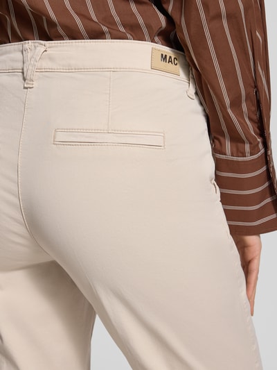 Frauenmodel trägt Chino mit Eingrifftaschen von MAC in Beige, Baumwoll-Elasthan-Mix, Regular Fit, Gesäßtasche, Nahaufnahme Rückansicht.