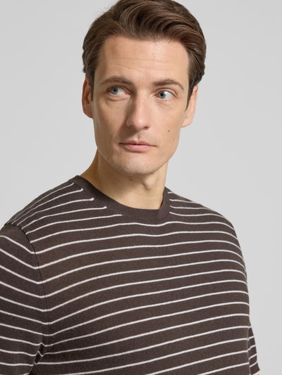 Männermodel trägt T-Shirt in Strick-Optik mit Kaschmir-Anteil von FTC-Cashmere, braun mit weißen Streifen, Nahaufnahme Oberkörper. Baumwoll-Lyocell-Mix, gerader Schnitt, Halbarm.