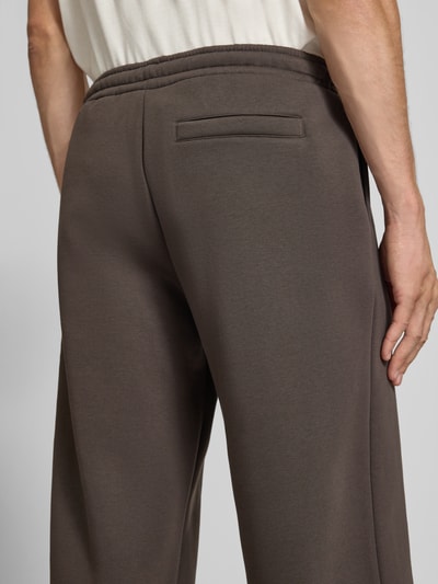 Männermodel trägt Straight Fit Sweatpants aus Baumwoll-Mix mit Label-Detail von REVIEW, graue Farbe, Detailaufnahme Rückansicht.