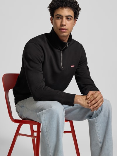 Męski model nosi Sweatshirt mit Label-Detail od Levi's®, czarny kolor, bawełna, regular fit, widok z przodu, ujęcie do połowy ciała.
