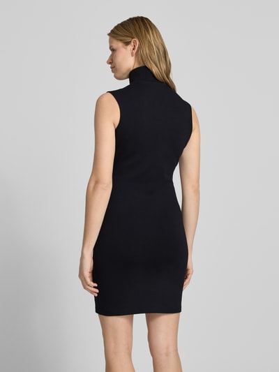 Frauenmodel trägt körpernahes Damen Jerseykleid aus Baumwoll-Mix Modell 'NUZIPPO_B' von Hugo Blue, Optik: Unifarben, Mini-Länge, Hochgeschlossen, Kontraststreifen, Label-Stitching, kurzer Reißverschluss, ohne Ärmel, Materialverarbeitung: Jersey, Ganzkörperansicht Rückansicht.