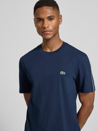 Męski model nosi Regular Fit T-Shirt aus reiner Baumwolle von Lacoste, granatowy, jednolity, krótki rękaw, label-tape, bawełna, zbliżenie górnej części ciała.
