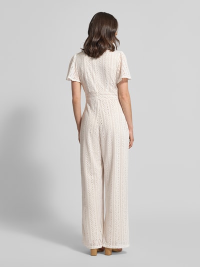 Frauenmodel trägt Jumpsuit mit Lochstickerei und rückseitigem Reißverschluss von Apricot in Creme, Ganzkörperansicht Rückansicht, Regular Fit, V-Ausschnitt, Rückenlänge 38 cm, Brustweite 43 cm, Ärmellänge 22 cm, Gesamtlänge 148 cm, Innenbeinlänge 75 cm, leichte Struktur mit feinen Durchbrüchen.