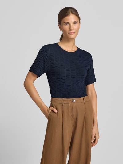 Frauenmodel trägt Slim Fit T-Shirt aus Viskose-Mix Modell 'NATACHA' von Cph Muse, dunkelblau mit Strukturmuster, Nahaufnahme Oberkörper.