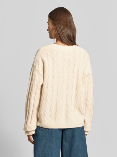 Frauenmodel trägt Relaxed Fit Pullover aus reiner Baumwolle von MYON in Strick-Optik, cremefarben, langärmlig, Ganzkörperansicht Rückansicht.