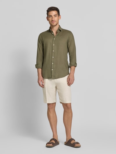 Męski model nosi Shorts aus Leinen mit Eingrifftaschen od MARKUP, beżowy len, krój straight fit, Szerokość w rozmiarze 50: 22 cm, Długość nogawki: 34 cm, widok całej sylwetki z przodu.