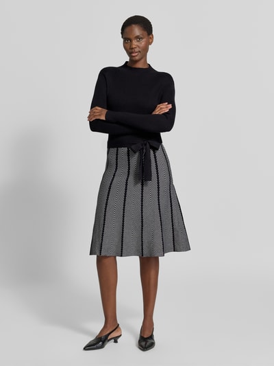 Kobiece modelka nosi Knielanges Kleid im 2-in-1-Look od Apricit, mieszanka wiskozy, linia a, długość do kolan, wiązany pasek, długość tyłu w rozmiarze S: 105 cm, szerokość w rozmiarze S: 39 cm, długość rękawów w rozmiarze S: 64 cm, ciemne i jasnoszare kolory, geometryczne wzory, gładka faktura, pełen widok z przodu.