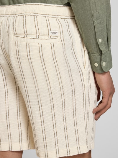 Männermodel trägt Regular Fit Shorts mit Tunnelzug von Jack & Jones aus Reine Baumwolle mit Gesäßtasche, cremefarben, Detailaufnahme Rückansicht.