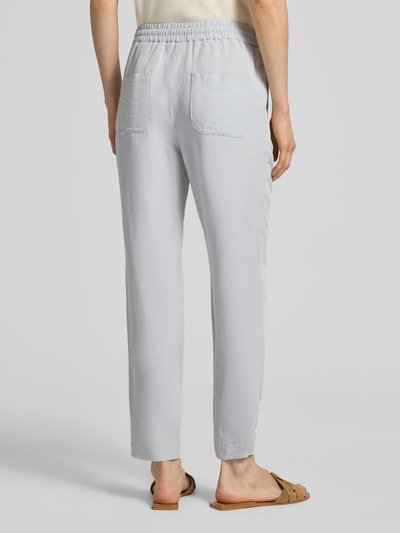 Frauenmodel trägt Straight Fit Stoffhose aus Viskose-Mix mit Leinen-Optik von Marc Cain, helle Farbe, elastischer Bund, Eingrifftaschen, Ganzkörperansicht Rückansicht, Bundweite 37 cm, Innenbeinlänge 66 cm in Größe 36.