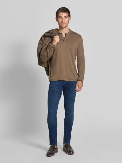 Männermodel trägt Slim Fit Jeans aus Baumwoll-Mix im 5-Pocket Design von Emporio Armani in Dunkelblau, Ganzkörperansicht von vorne. Elastischer Baumwoll-Mix, Knopf- und Reißverschluss, Bundweite 42 cm, Innenbeinlänge 84 cm.