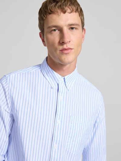Männermodel trägt Classic Fit Freizeithemd mit Button-Down-Kragen von Calvin Klein Jeans, blau-weiß gestreift, Baumwoll-Elasthan-Mix, Nahaufnahme Oberkörper. Brusttasche, Label-Stitching, Knopfleiste sichtbar, Größe M: Rückenlänge 81 cm, Schulterbreite 46 cm, Ärmellänge 65 cm.