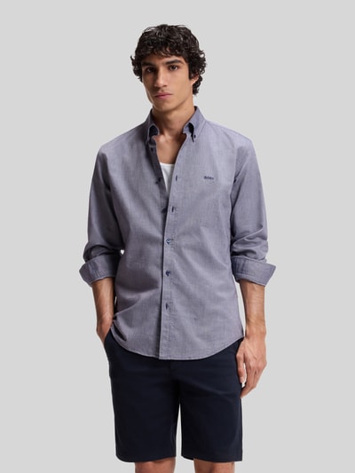 Männermodel trägt Regular Fit Freizeithemd aus Oxford-Baumwolle Modell 'RICKERT' von BOSS Orange in Melange-Optik, Ganzkörperansicht von vorne.