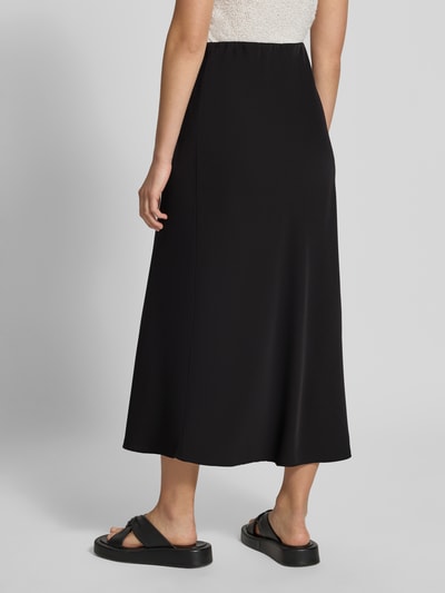 Frauenmodel trägt Ausgestellter Maxi-Rock mit elastischem Bund Modell 'FRANAN' von PIECES, schwarze Farbe, glatte Textur, Ganzkörperansicht Rückansicht, Damen Maxi-Rock von PIECES.