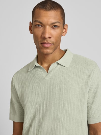 Męski model nosi Regular Fit Poloshirt aus Baumwoll-Leinen-Mix Modell 'MATTIS' von SELECTED HOMME, efekt: jednolity kolor, z fakturą, z naszywką z logo, kołnierzyk polo, dekolt w serek, krótki rękaw, mieszanka bawełny i lnu, zbliżenie na górną część ciała