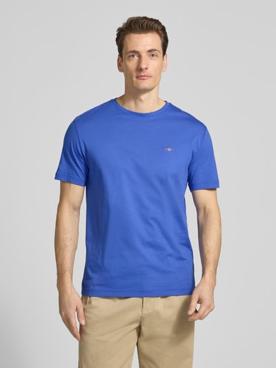 Männermodel trägt Regular Fit T-Shirt mit Logo-Stitching von Gant in blau, reine katoen, ronde hals, herenmode, ganzkörperansicht von vorne.