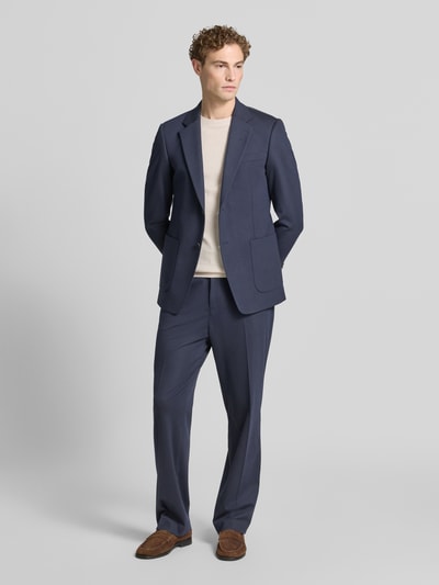 Männermodel trägt Regular Fit Stoffhose aus Viskose-Mix Modell 'ISCOVE' von Tiger Of Sweden, dunkles Blau, Bundfalten, Ganzkörperansicht von vorne. Kontext: Herren Stoffhose, Tunnelzug, Bundweite bei Größe 50: 42 cm, Innenbeinlänge bei Größe 50: 82 cm.