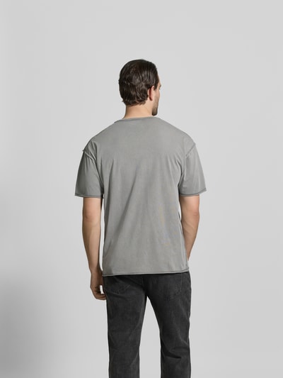 Männermodel trägt Regular Fit T-Shirt mit Logo-Detail von Diesel in Grau, Reine Baumwolle, Rundhalsausschnitt, Kurzärmelig; Ganzkörperansicht Rückansicht.